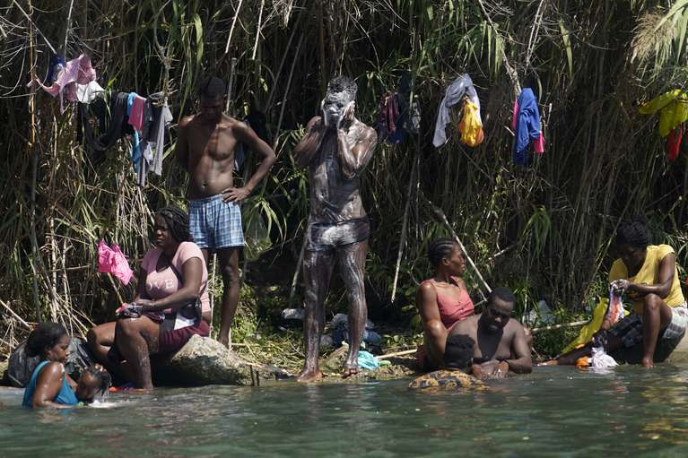 Los migrantes haitianos se bañan y lavan su ropa a orillas del Río Bravo luego de cruzar a Estados Unidos desde México, el sábado 18 de septiembre de 2021, en Del Rio, Texas.  (Foto AP / Eric Gay)