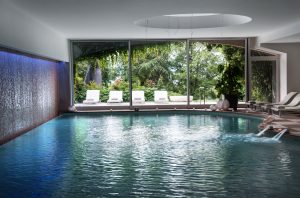 Una piscina cubierta con vistas a exuberantes jardines en Italia