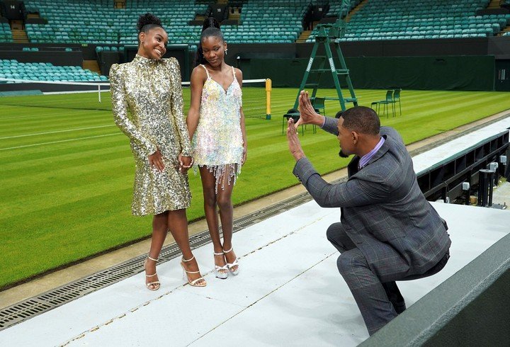Will finge que toma una foto de Saniyya Sidney y Demi Singleton, Venus y Serena en la ficción, en el estadio de Wimbledon.  Foto AP