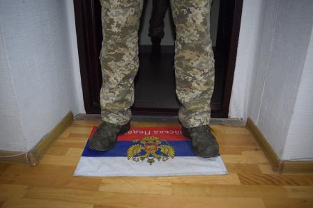 Un soldado ucraniano pisa la alfombra con una bandera rusa dándole la bienvenida a la sala de reuniones del Hospital de la Guardia Fronteriza de Kyiv.